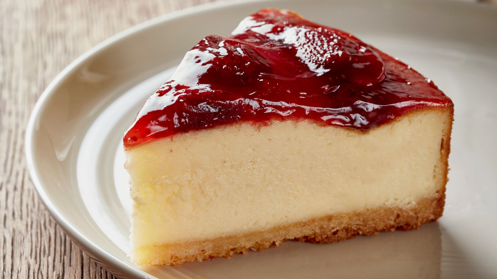 a piece of cheesecake on a plate next to a cup of coffee