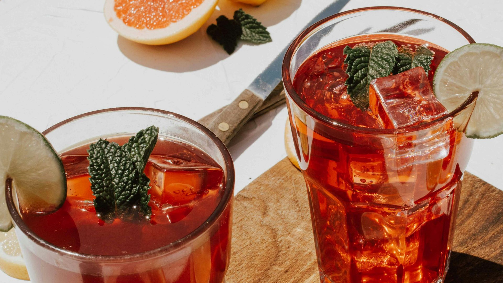 two clear drinking glasses with filled red liquid