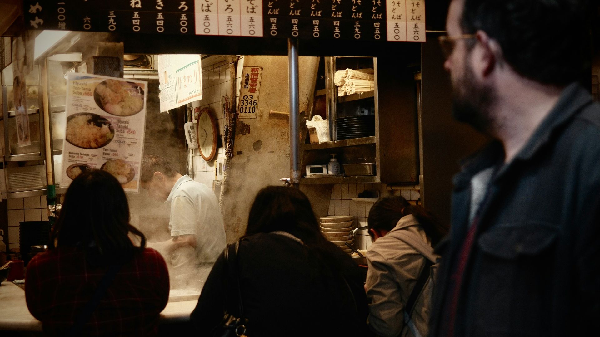 People eating at a busy japanese restaurant counter