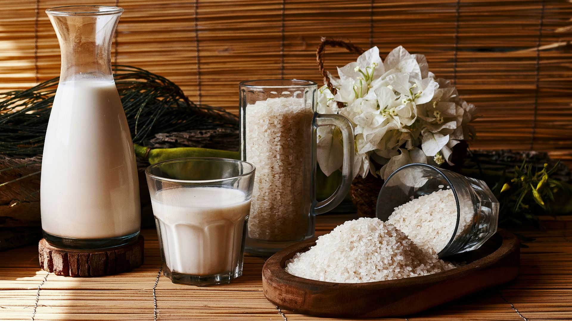 a table topped with a pitcher of milk next to a glass of milk