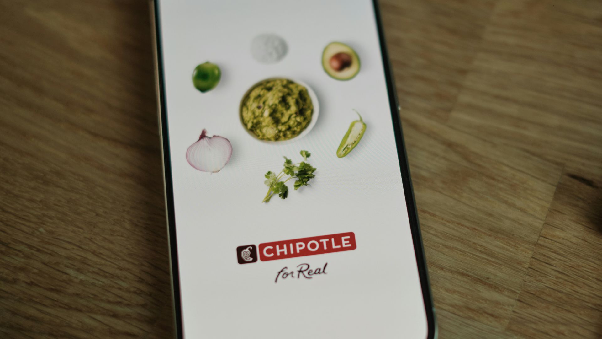 A cell phone sitting on top of a wooden table