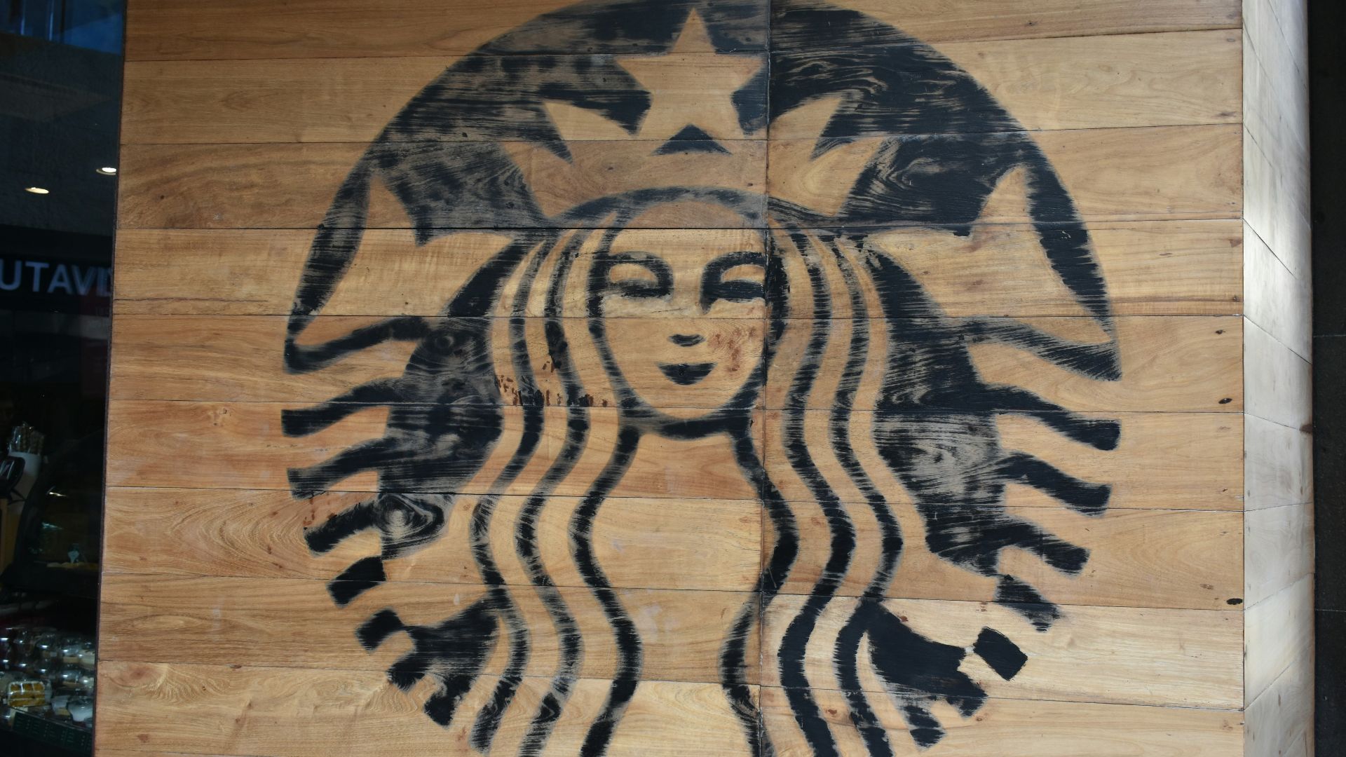 a starbucks sign painted on a wooden wall