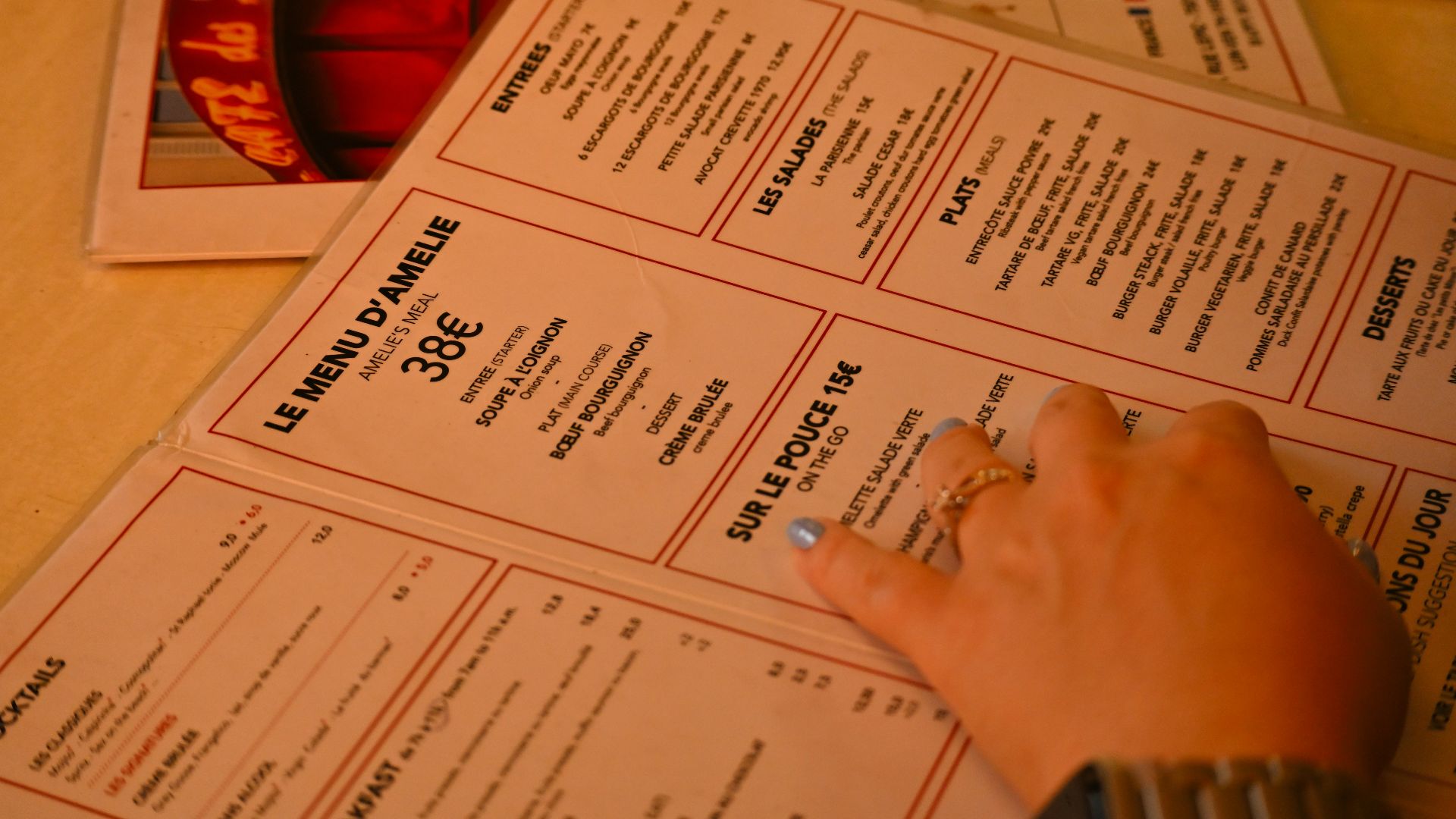 A person's hand on top of a menu