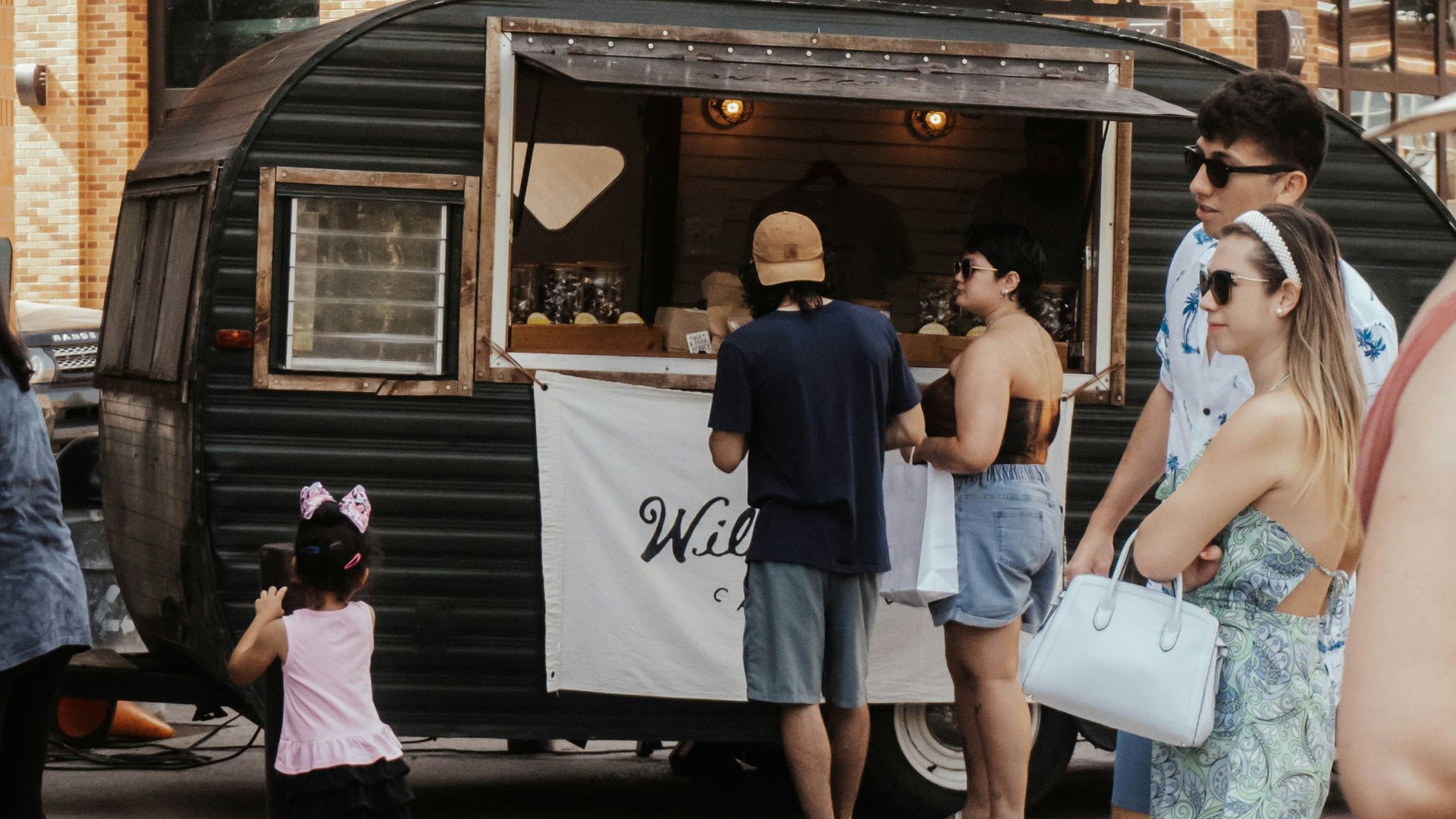 a group of people standing around a food truck