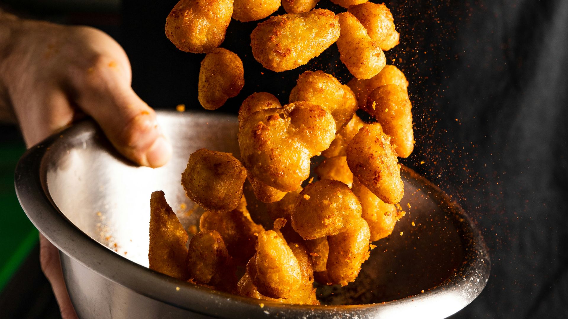 a person holding a bowl of fried food