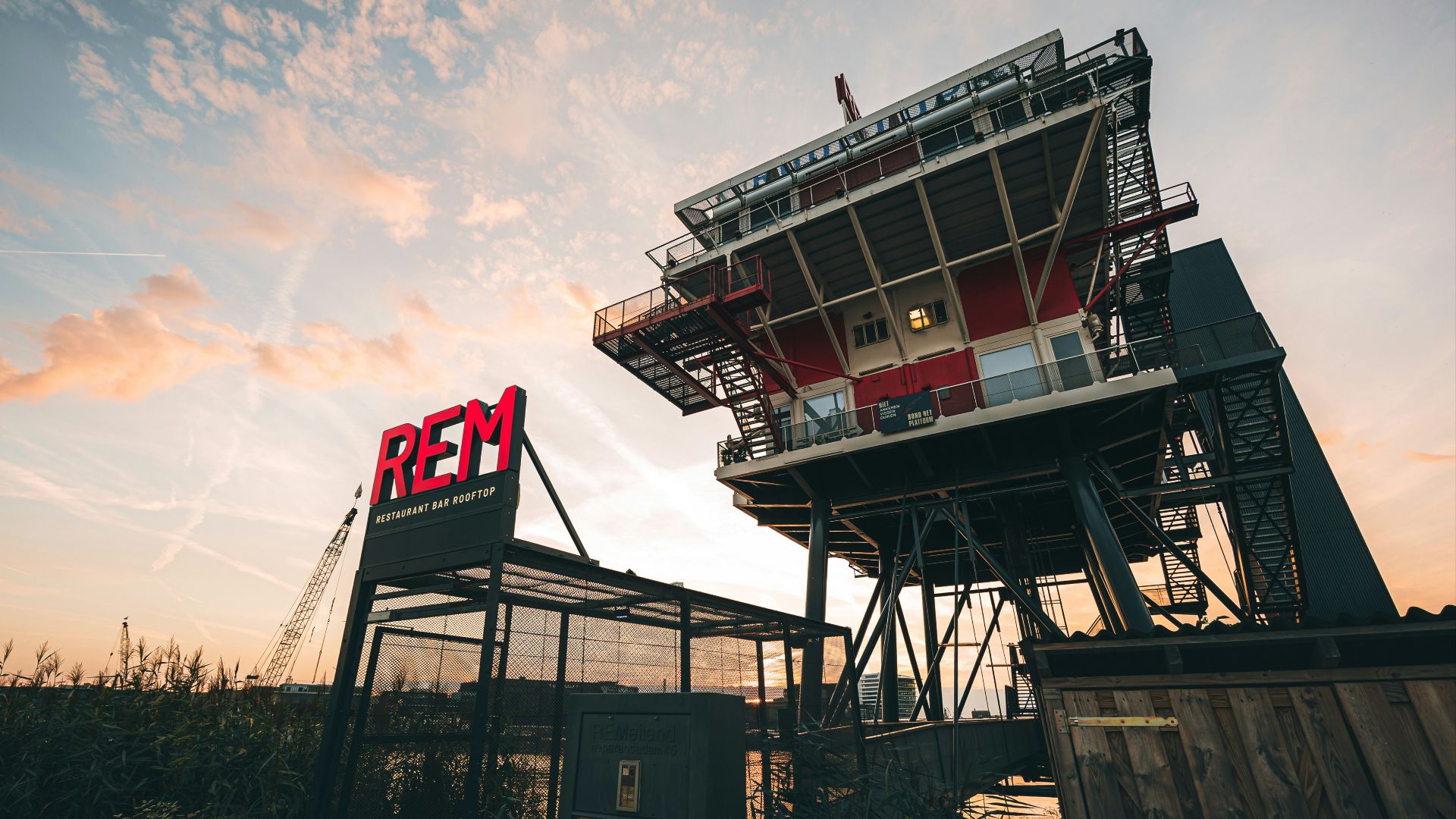 A red sign sitting on top of a metal structure
