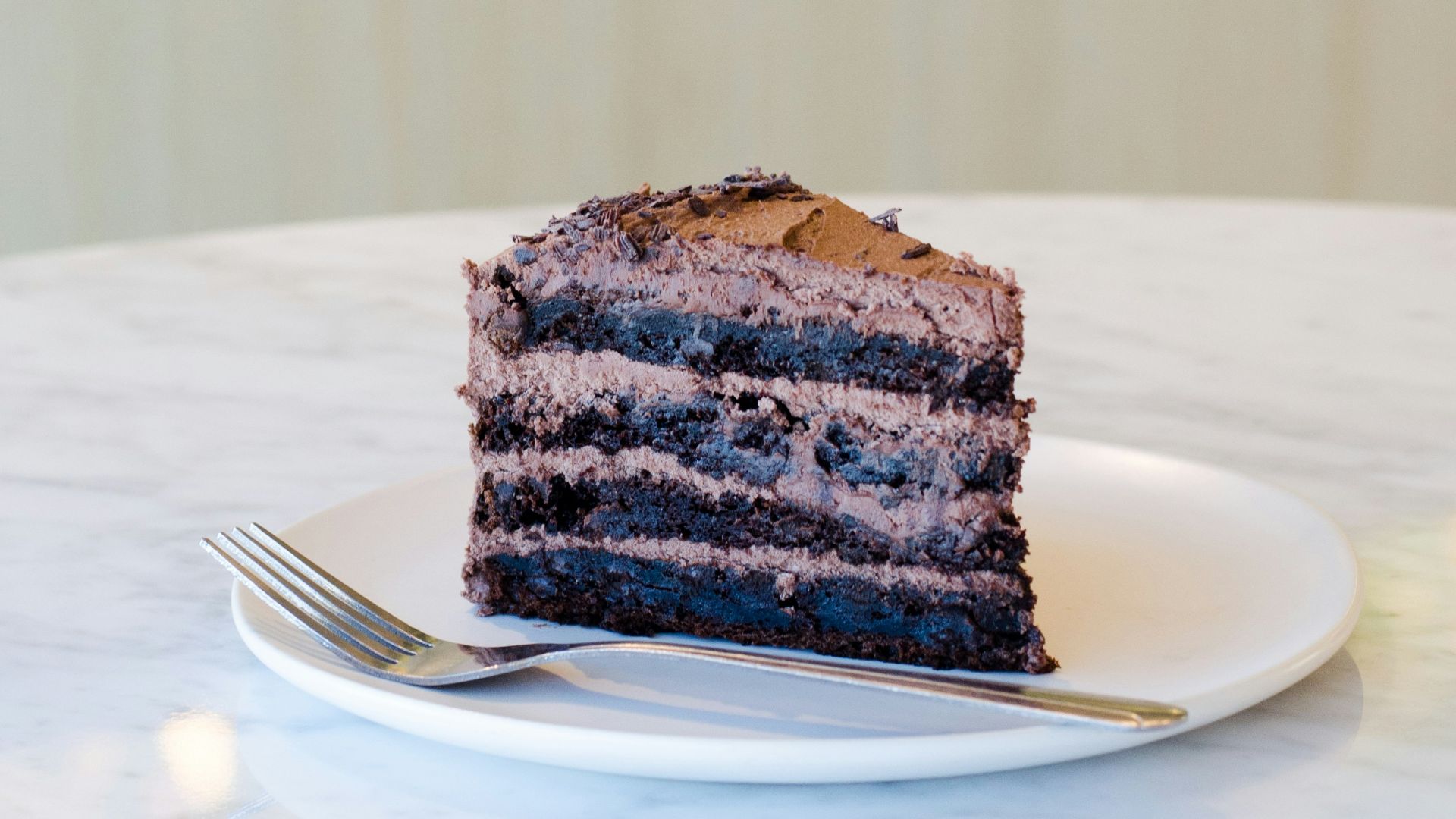 sliced chocolate cake beside fork on plate