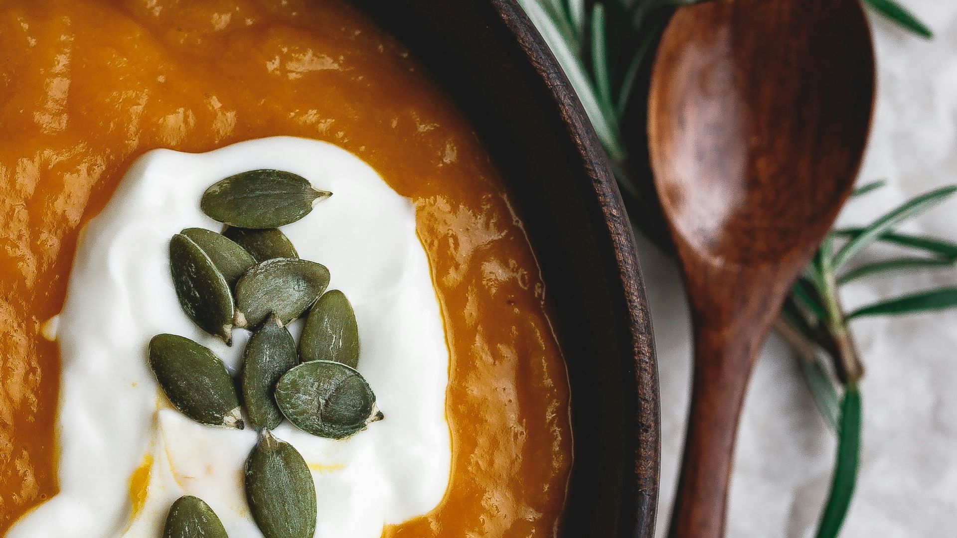 stew in round wooden bowl beside wooden spoon