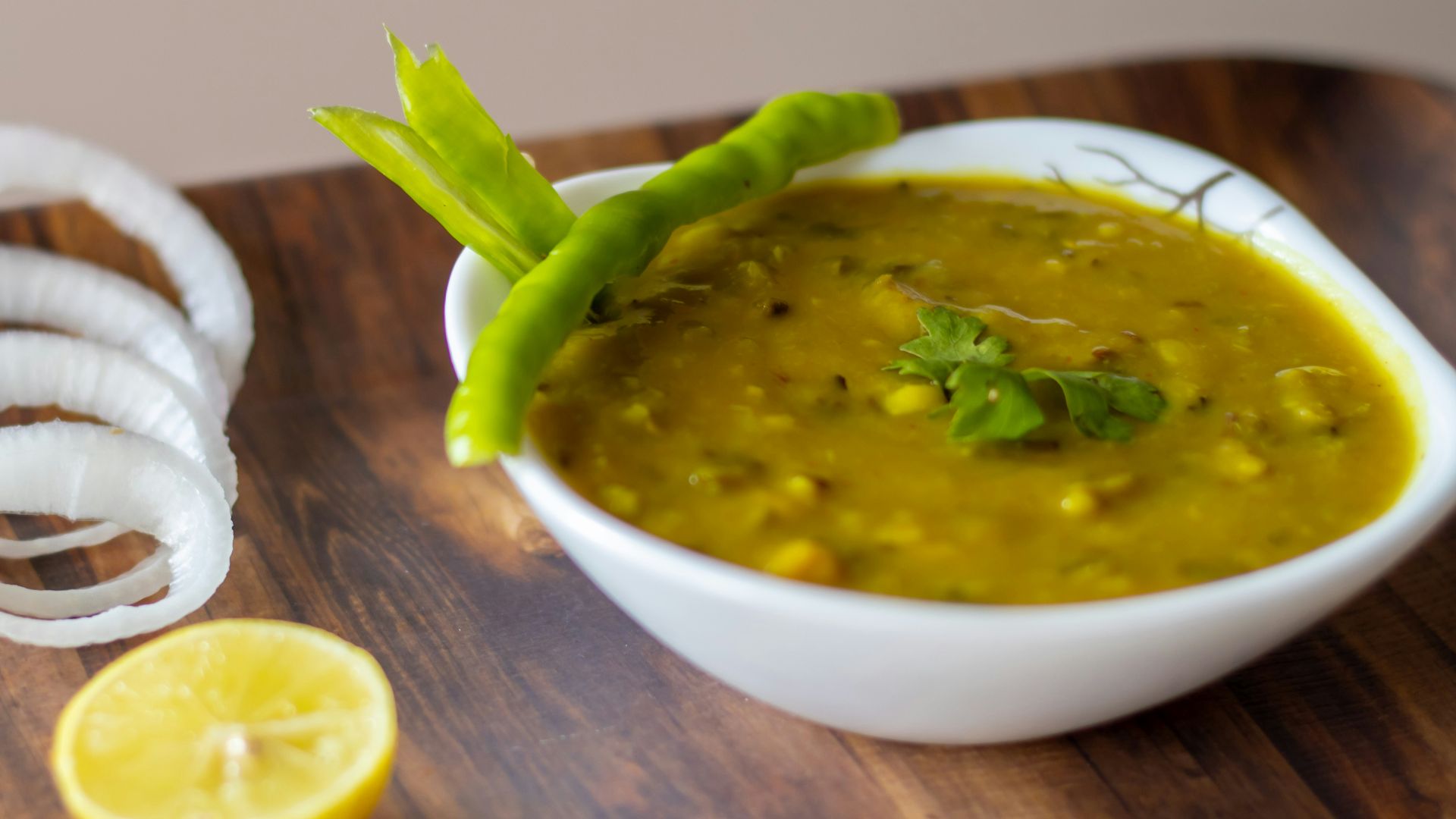 sliced orange fruit beside white ceramic bowl with green soup