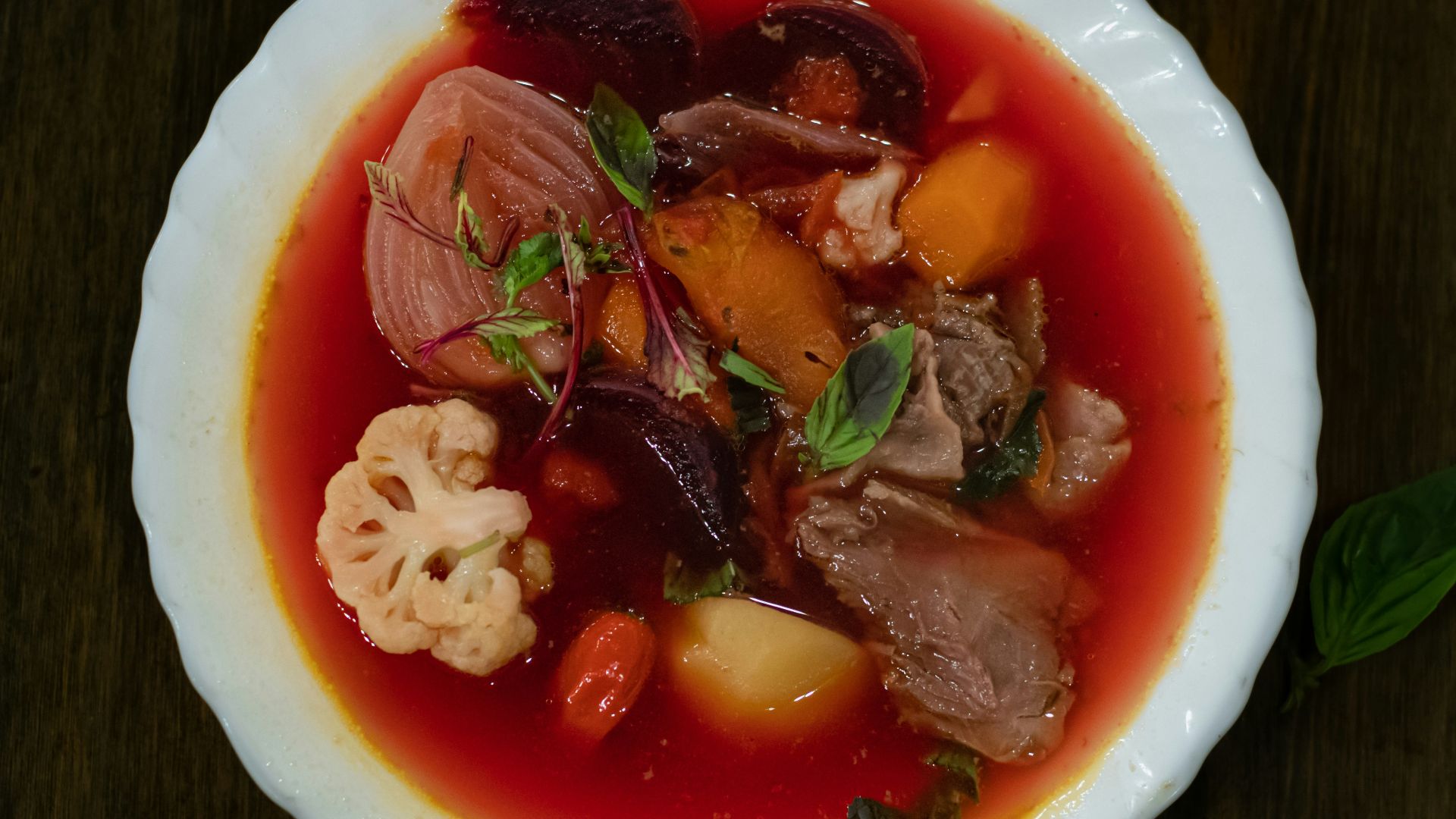 a white bowl filled with meat and vegetables