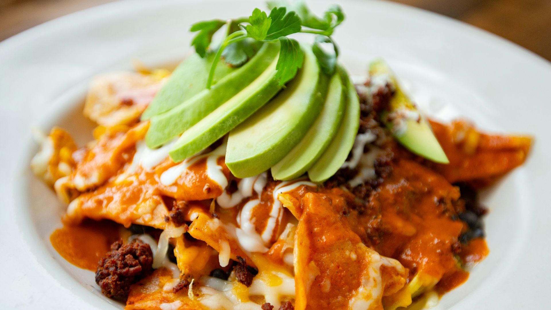 a plate of mexican food with avocado on top