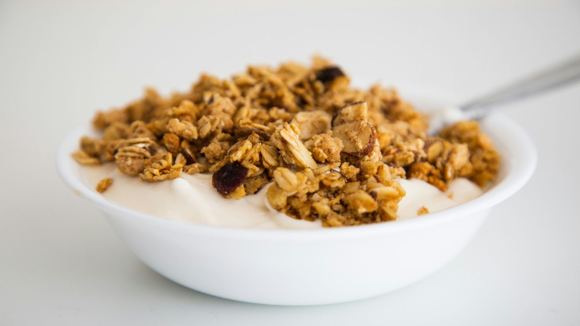 a bowl of granola and yogurt with a spoon