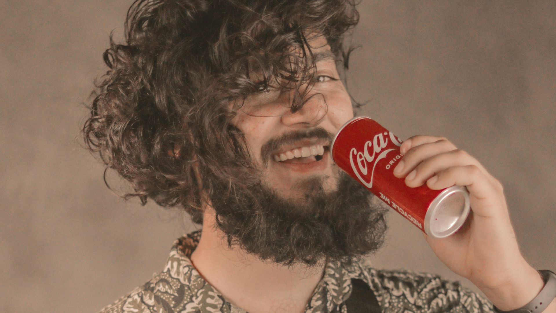 a man with a beard drinking a coca cola