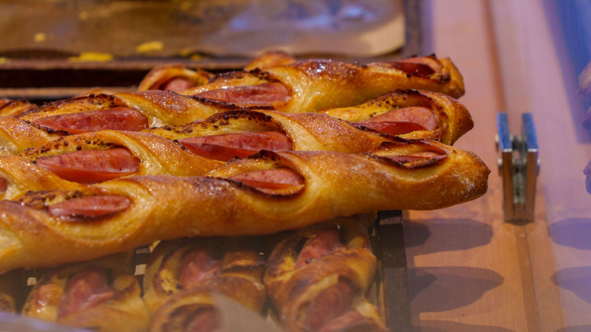 Pastries with sausage are displayed in a shop.