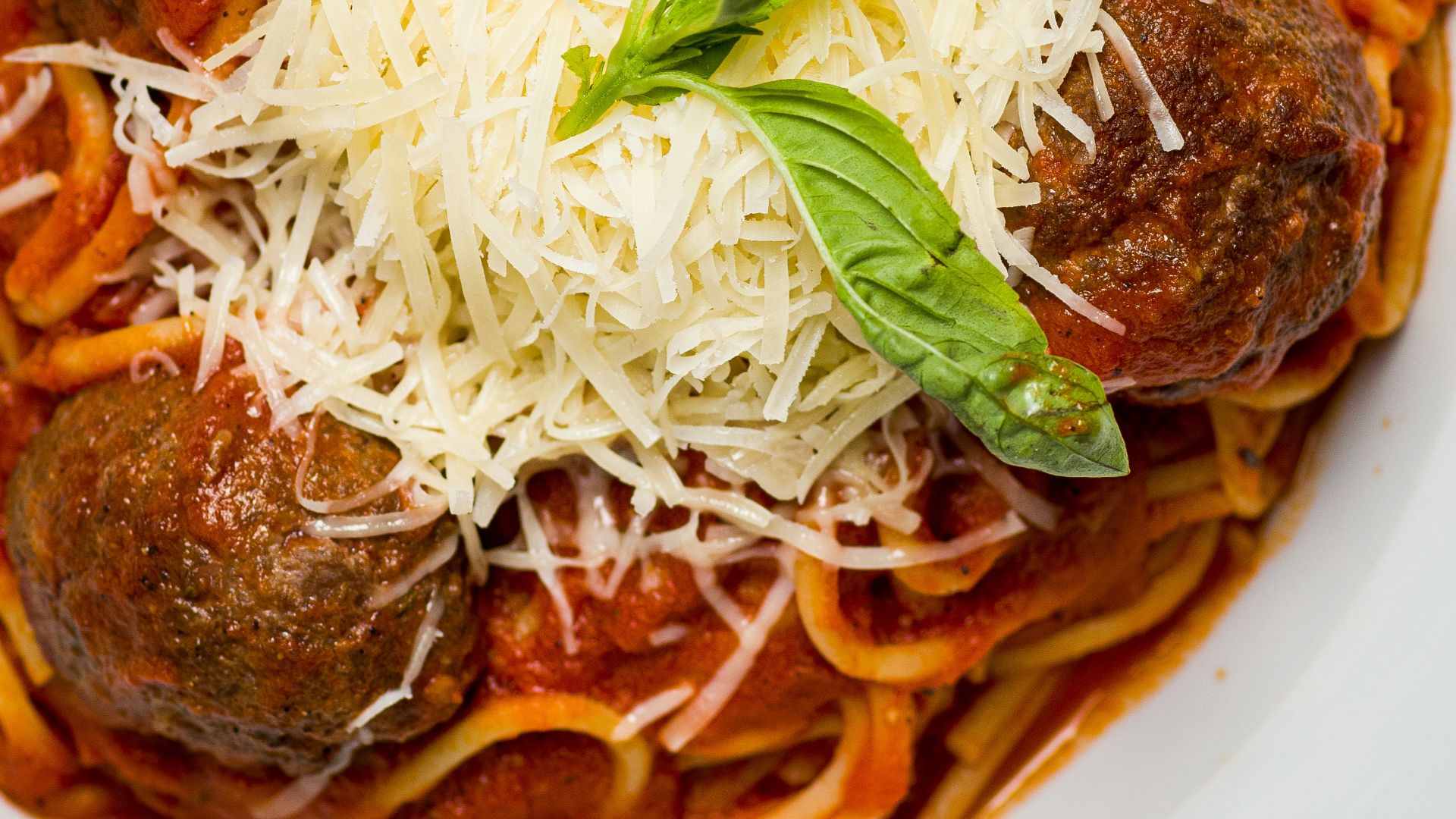 a white plate topped with spaghetti and meatballs