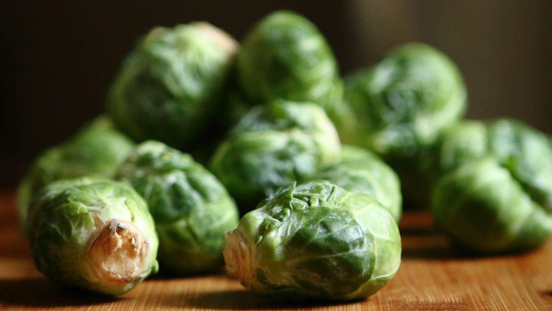 shallow depth of fields photography of green vegetable on brown wooden panel