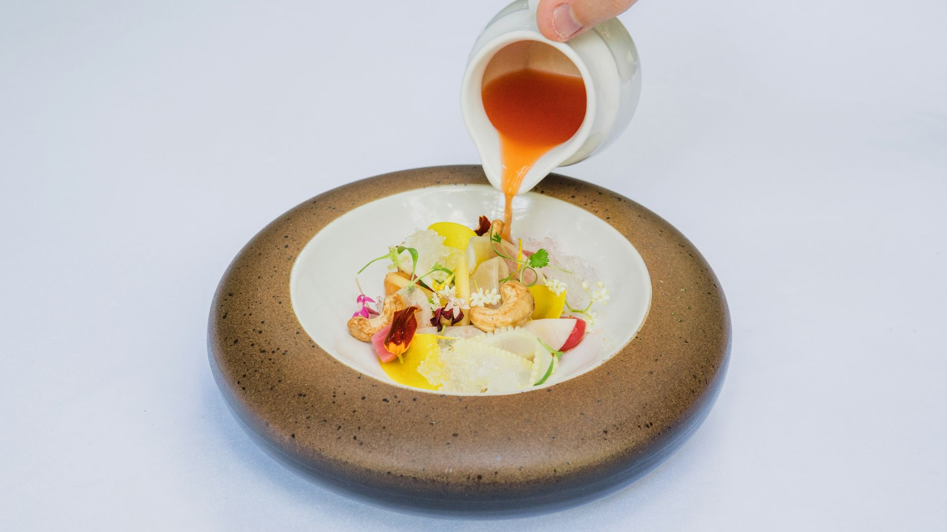 person holding white ceramic bowl with soup