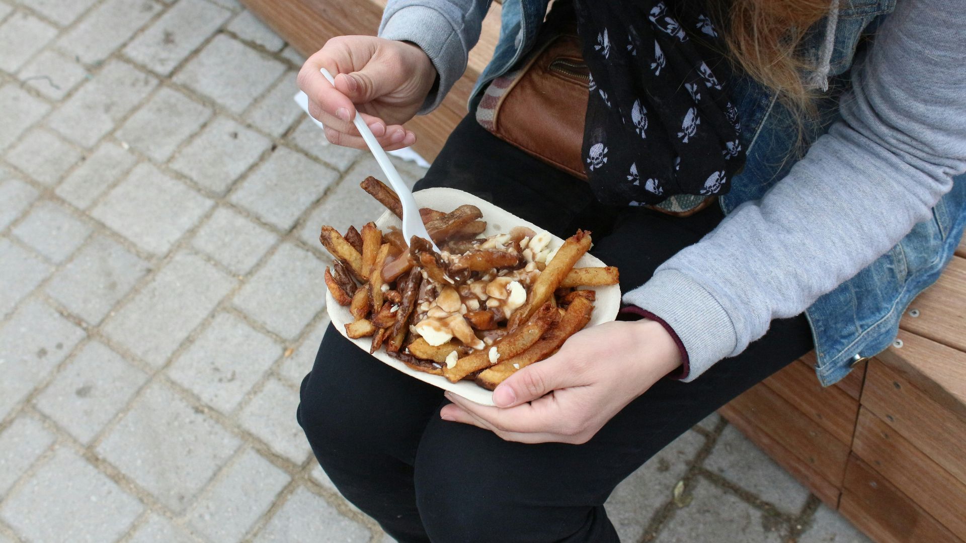 person holding burger with fries