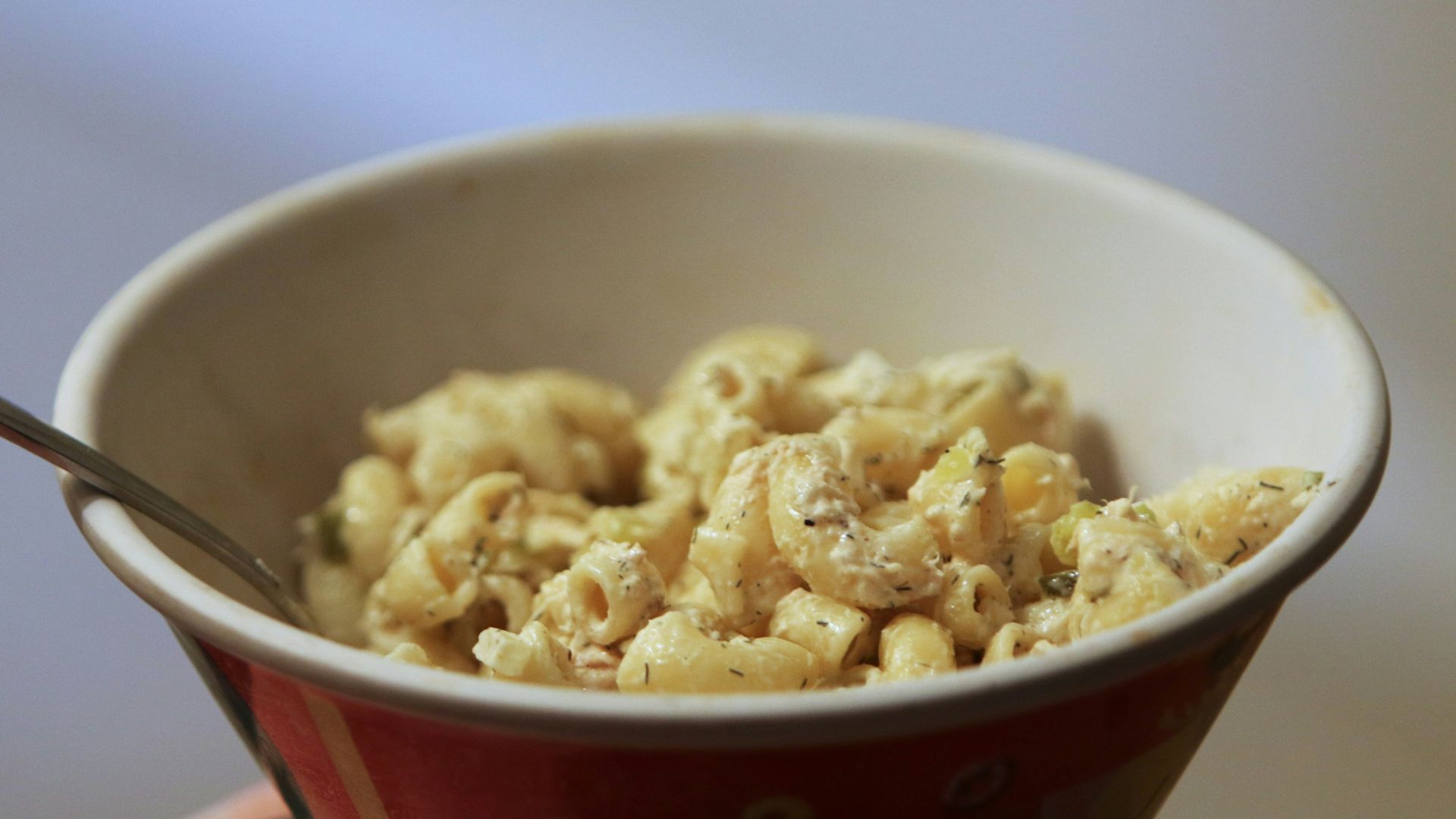 a bowl of macaroni and cheese with a spoon in it