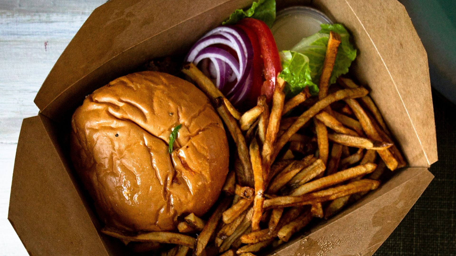 burger and fries on brown paper bag