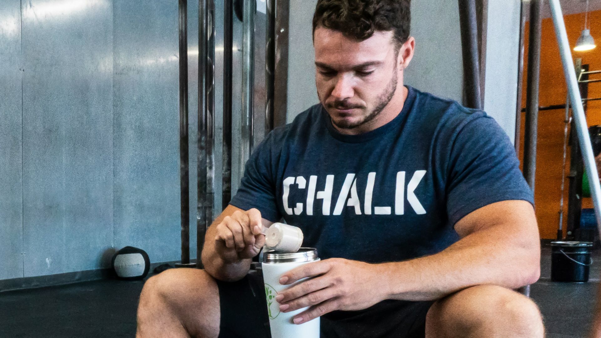 man in black crew neck t-shirt holding white plastic cup
