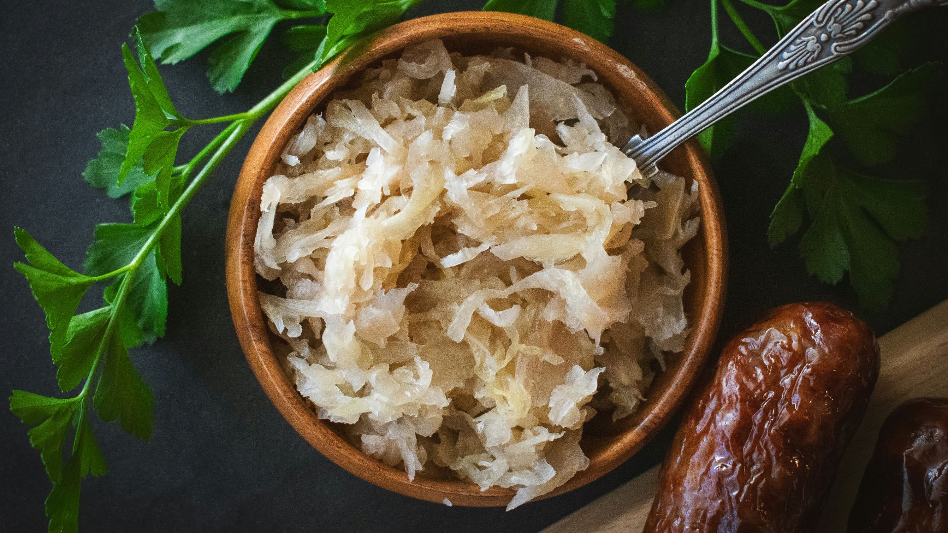 a wooden bowl filled with rice next to a spoon