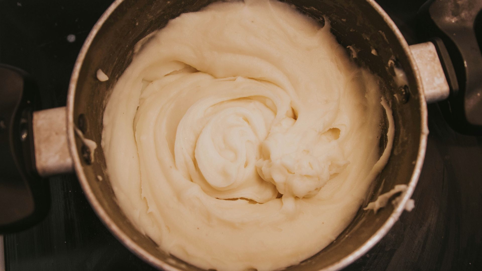 a pot of cream sitting on top of a stove