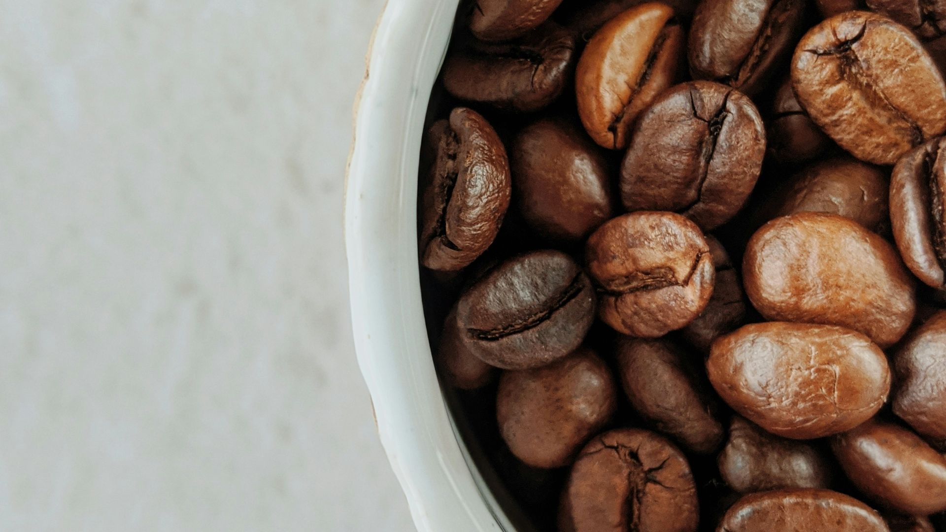 brown coffee beans on white ceramic bowl