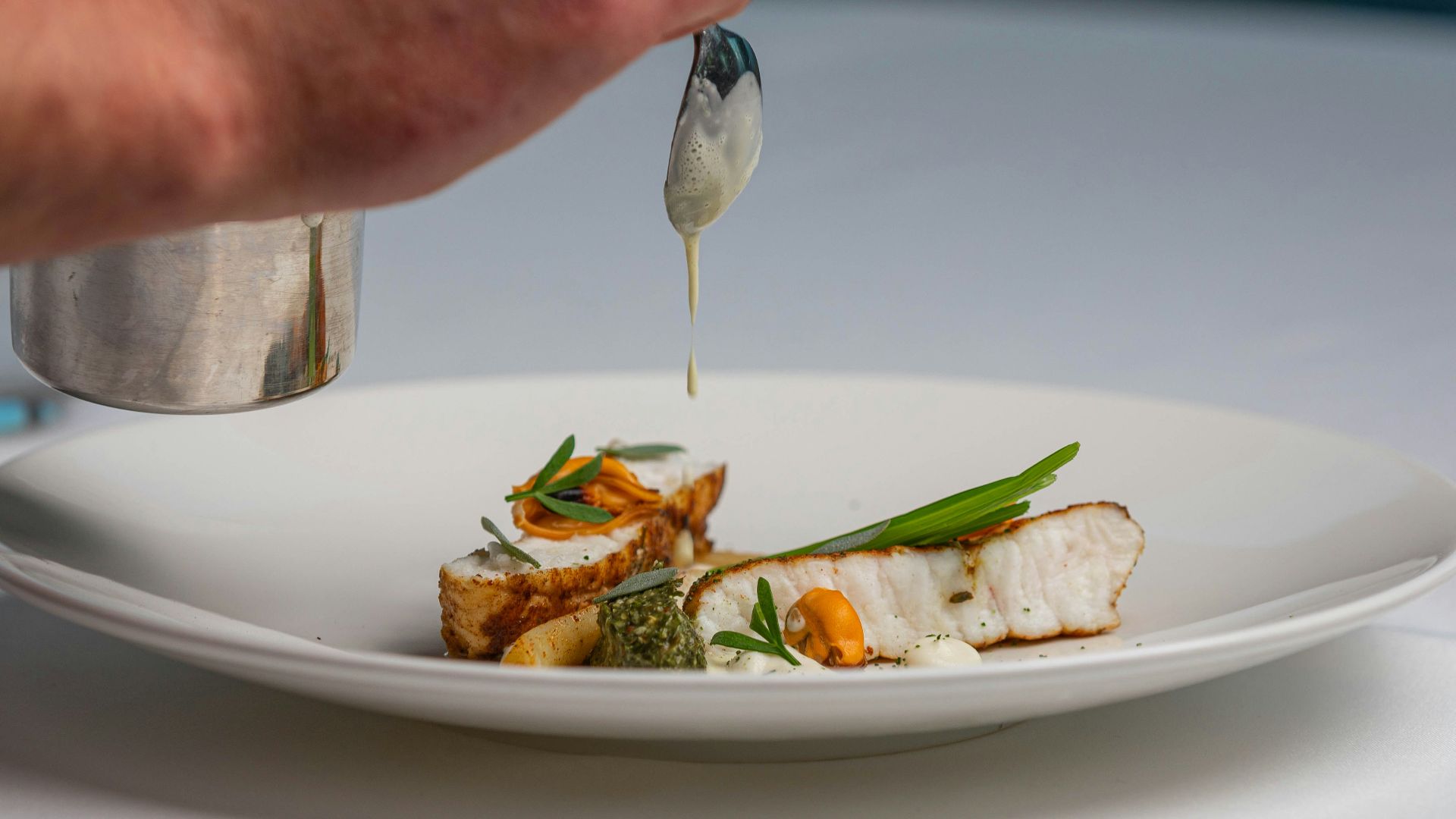 a white plate topped with fish and vegetables