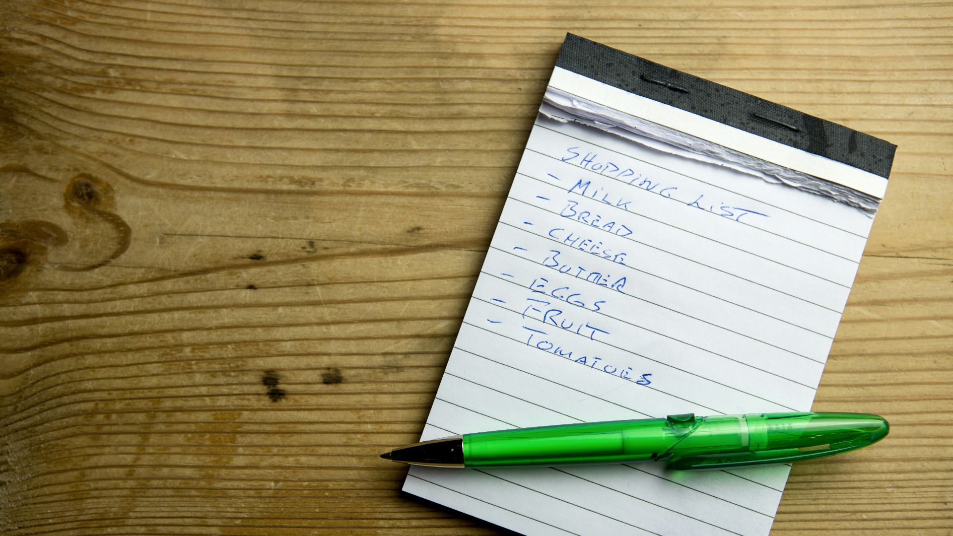 a notepad with a green pen on top of it