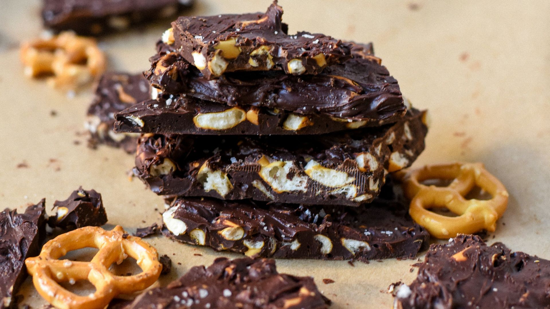a pile of chocolate covered pretzels on top of a piece of parchment paper