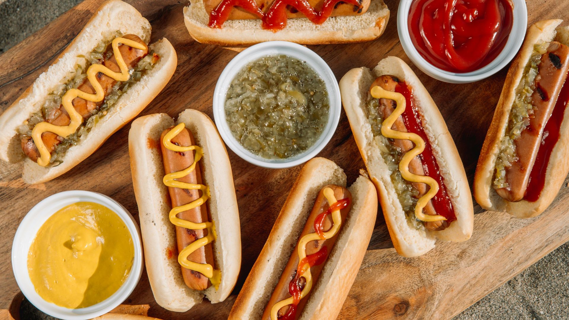 hotdog sandwich with sauce on brown wooden tray