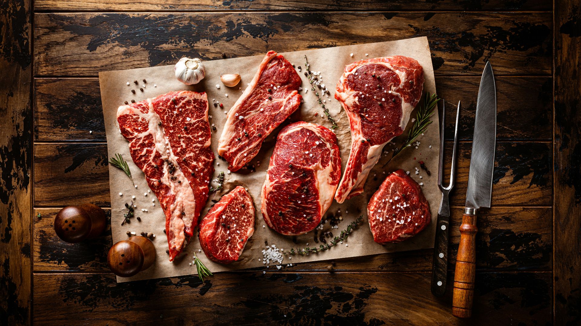 raw meat on a cutting board next to a knife