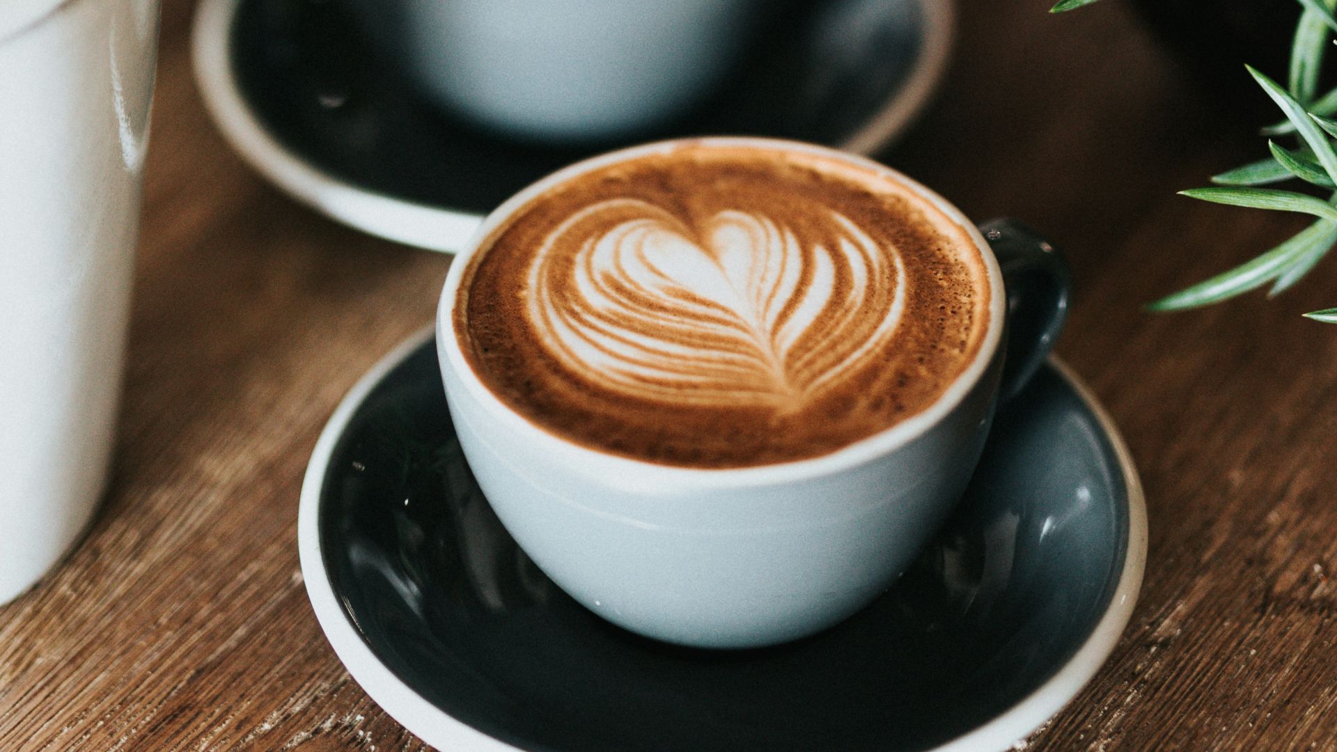 shallow focus photography of coffee late in mug on table
