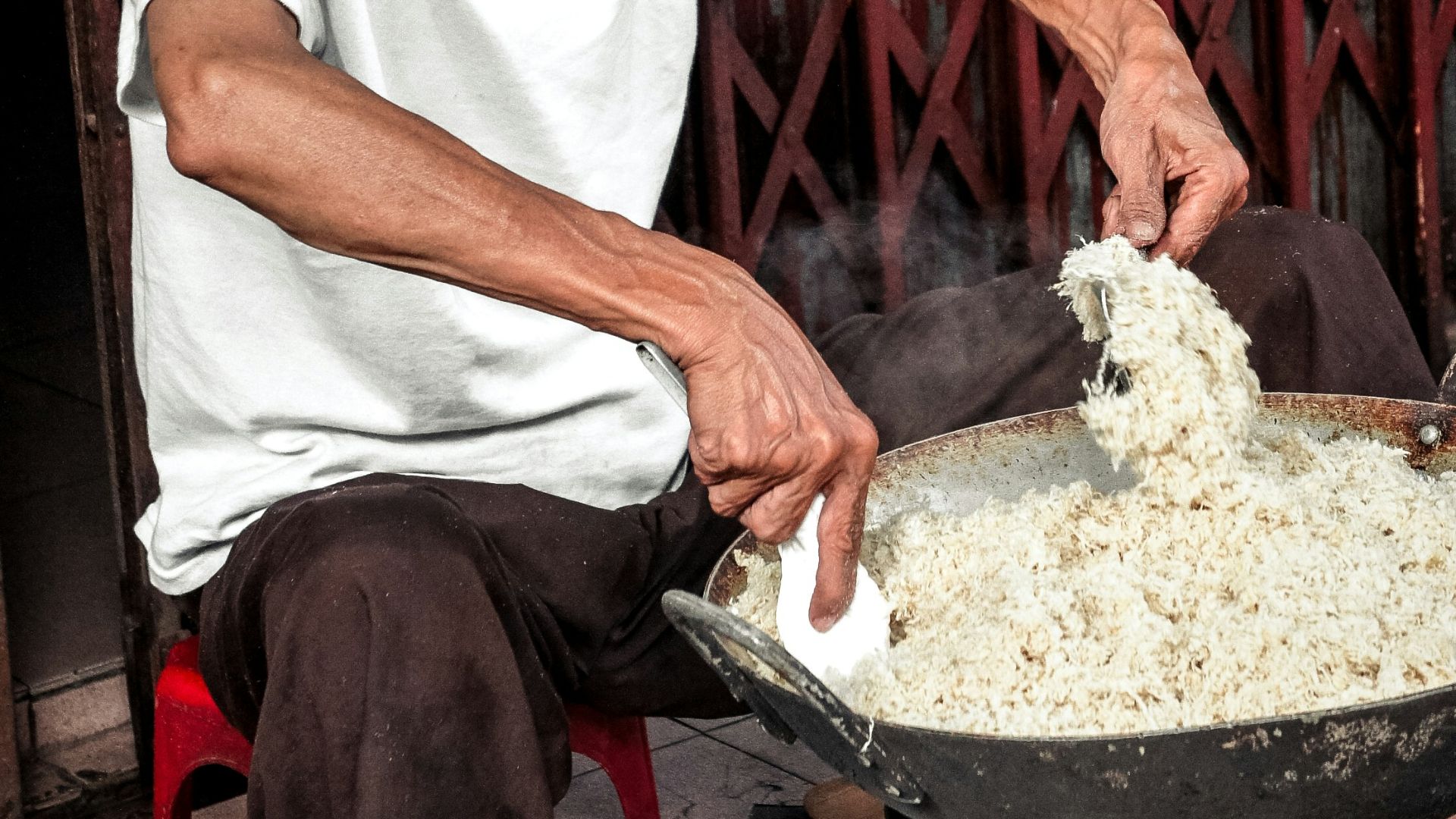 man in white crew-neck t-shirt cooking in wok