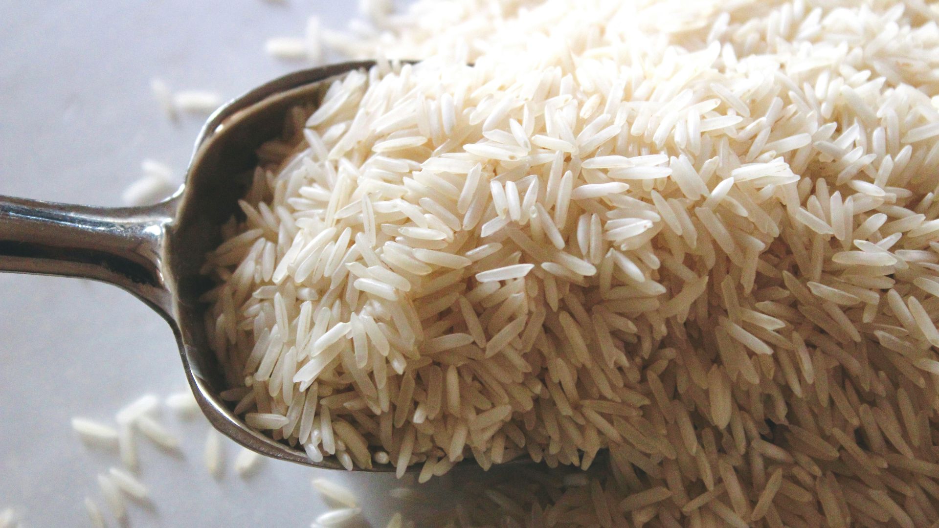 a spoon filled with rice on top of a table