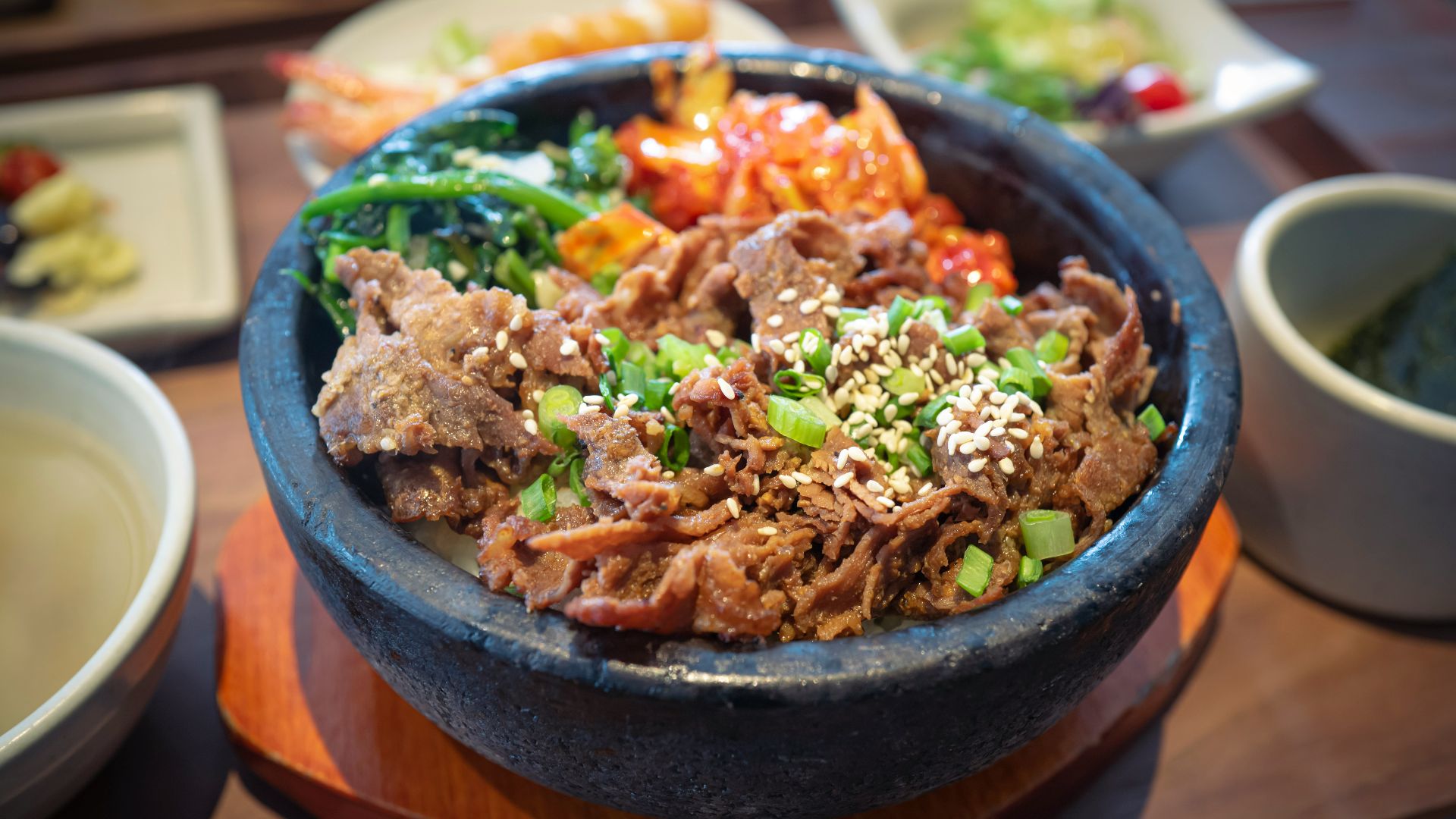 a bowl filled with meat and vegetables next to a bowl of soup