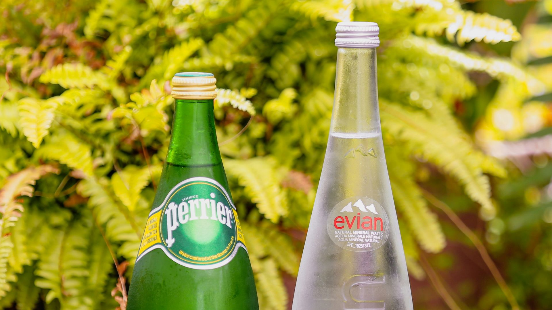 two green glass bottles on brown wooden table