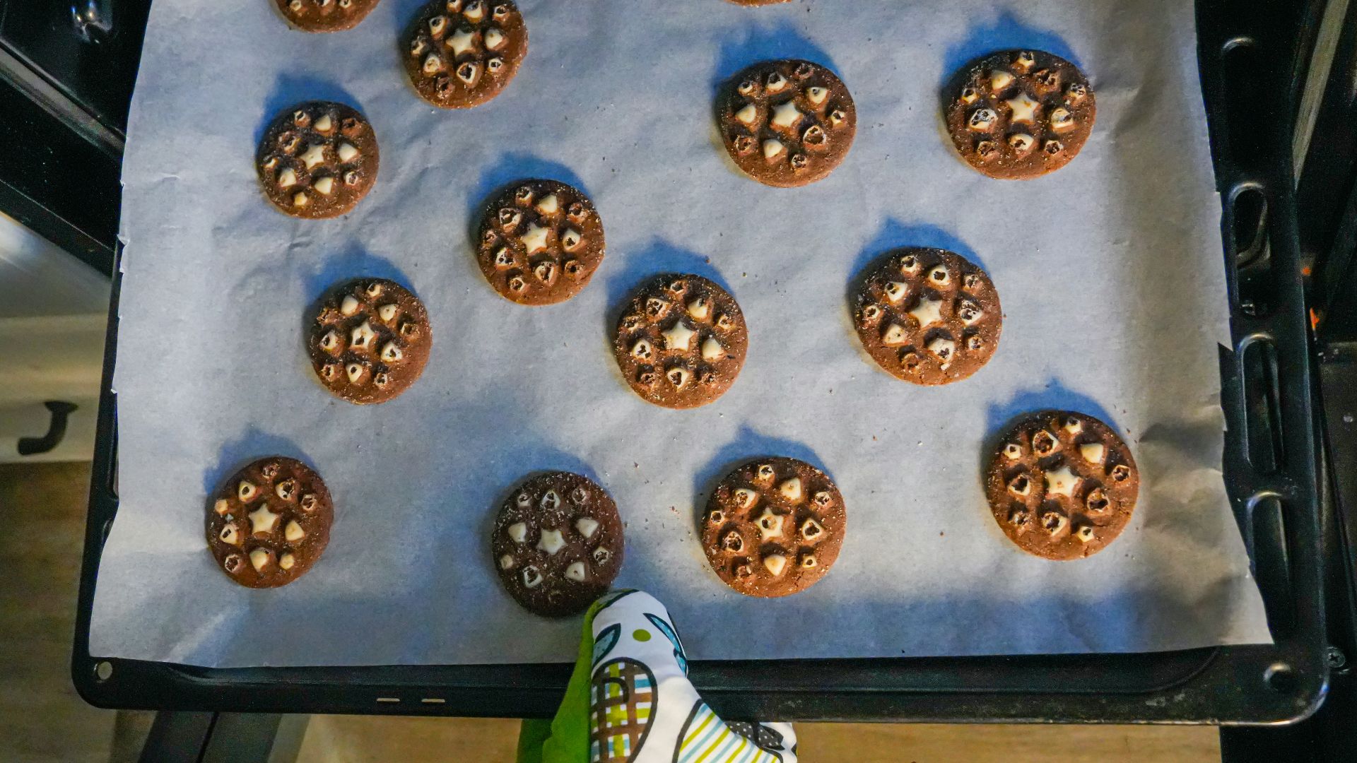 Chocolate cookies with white centers on baking sheet.