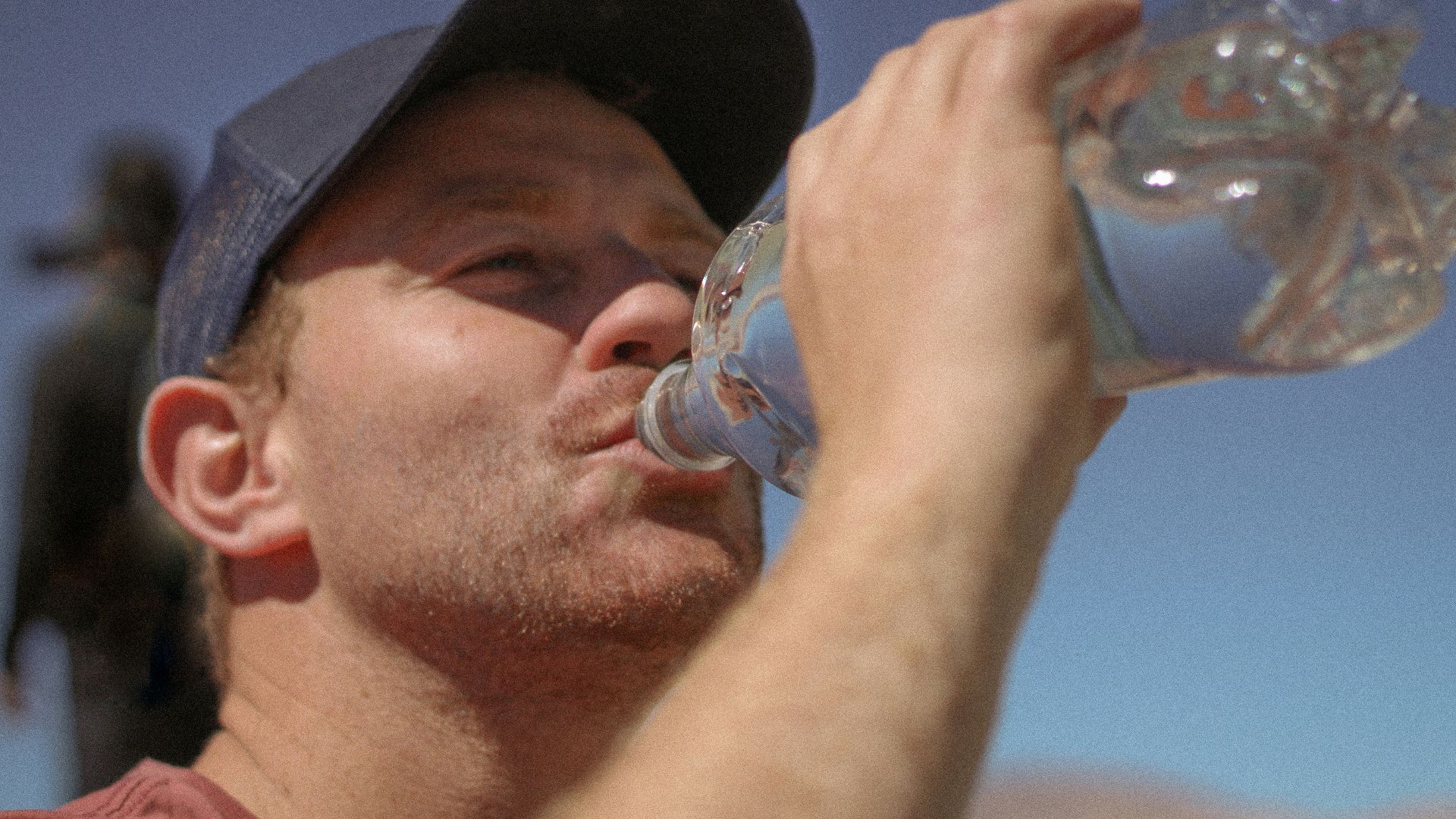 a man drinking water out of a bottle