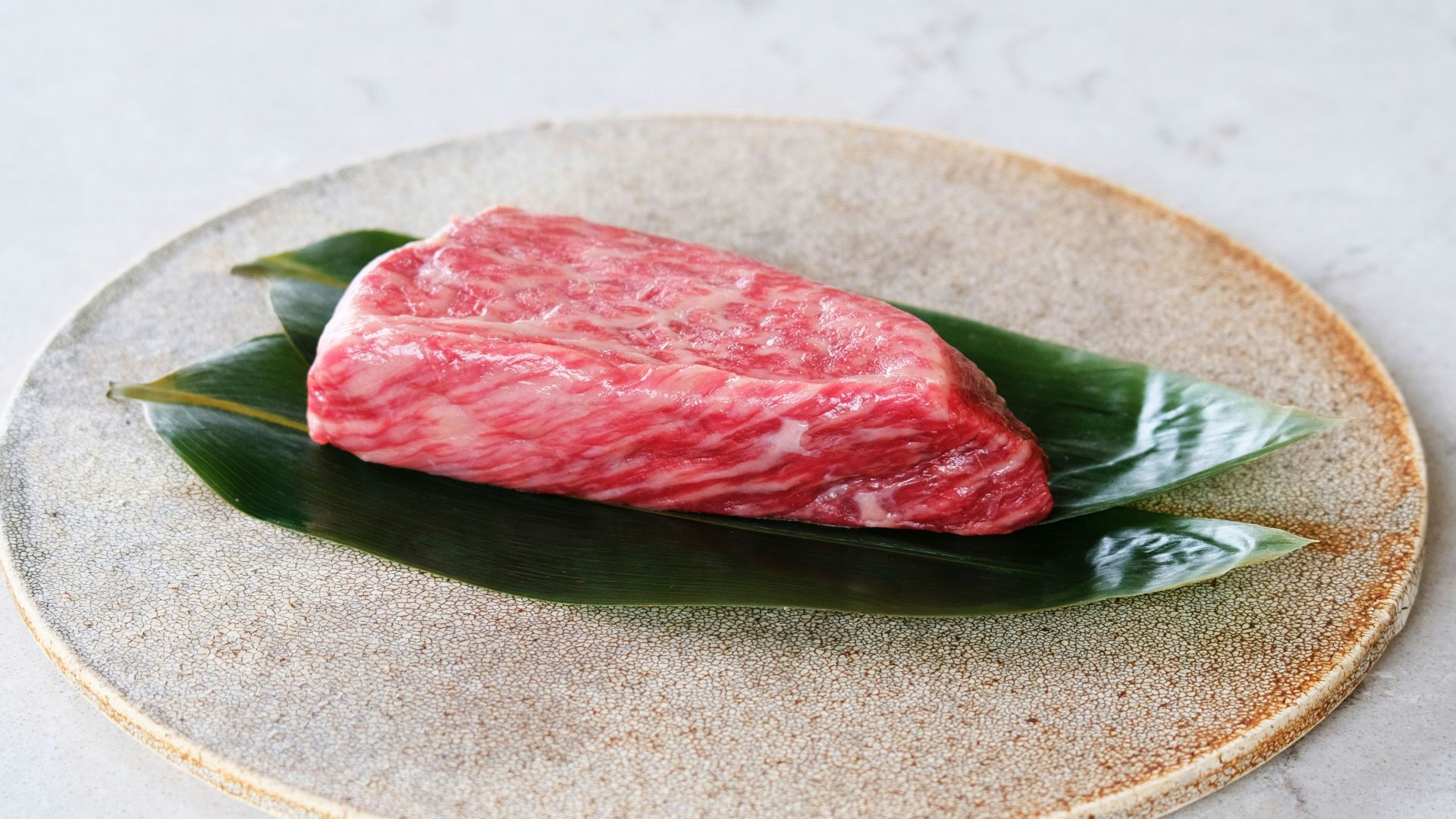 raw meat on white and green floral ceramic plate
