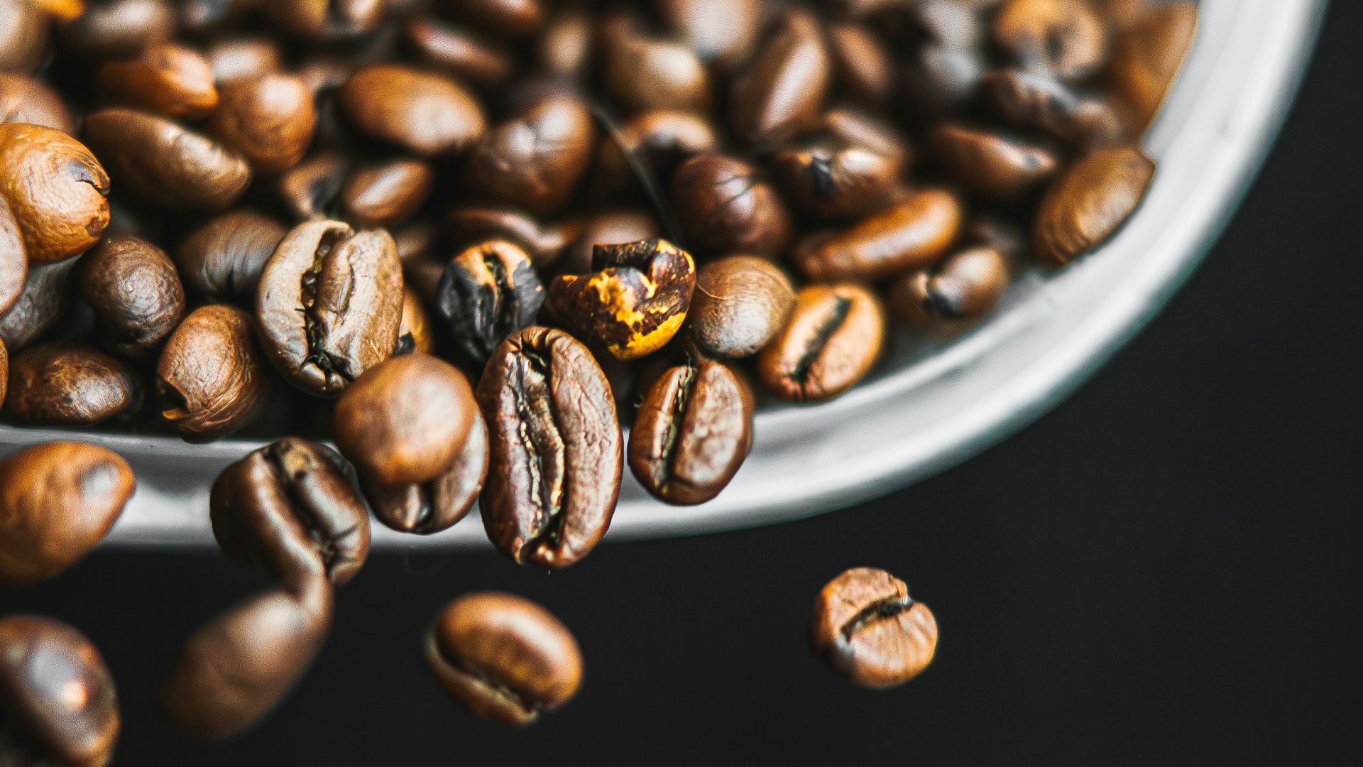 a spoon full of coffee beans on top of a table