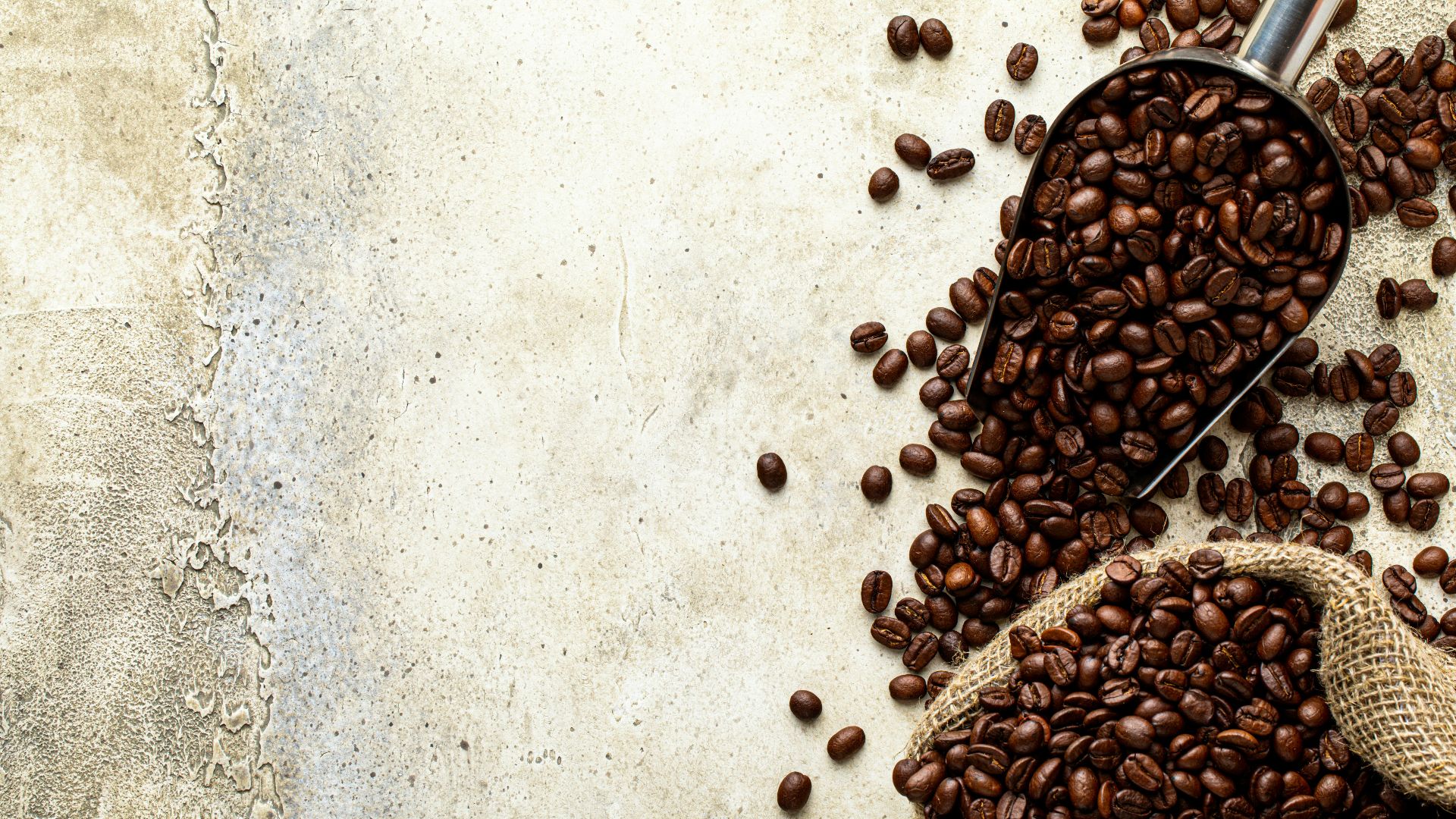 a scoop full of coffee beans next to a sack of coffee beans