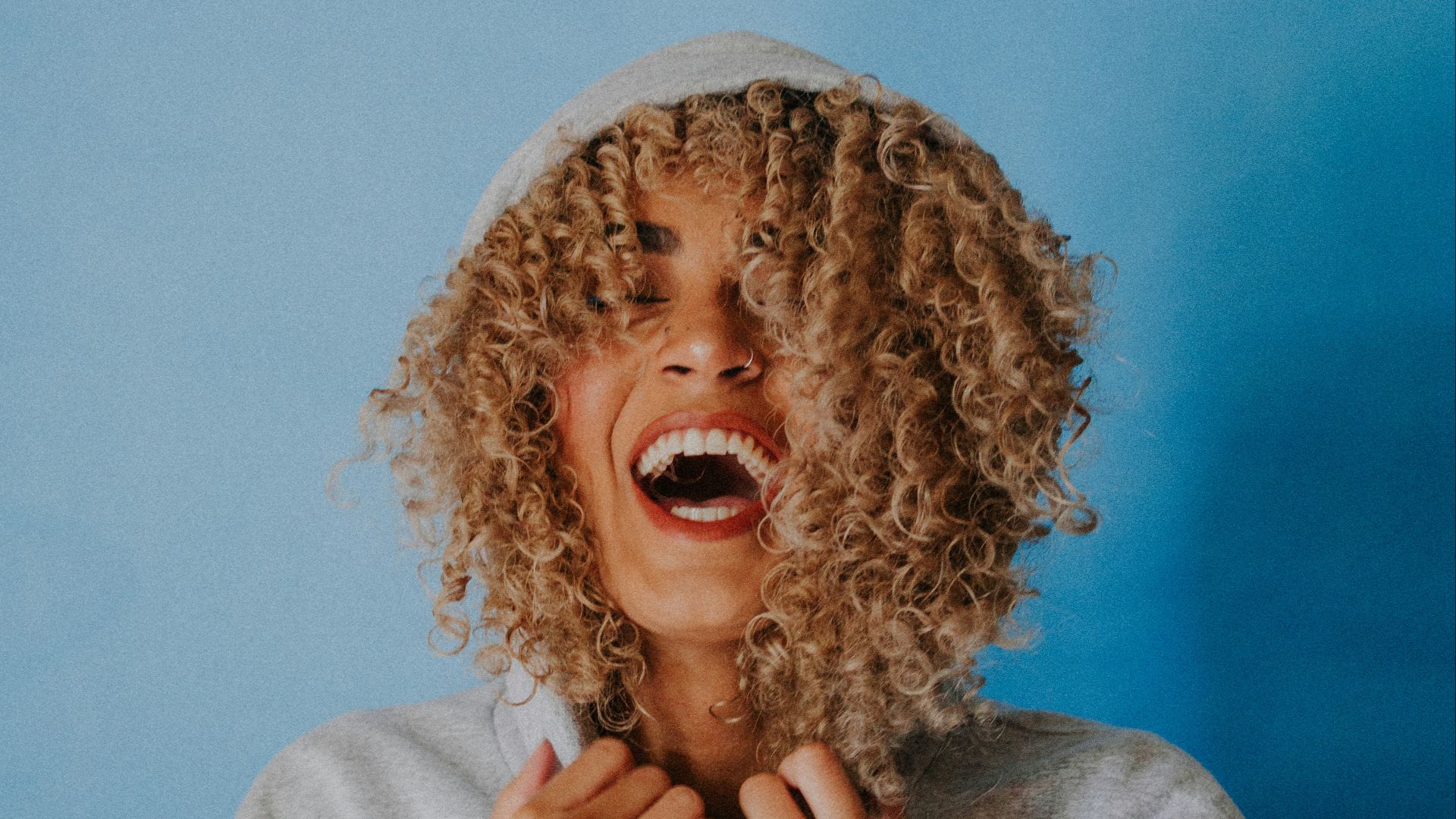 smiling woman wearing gray hoodie