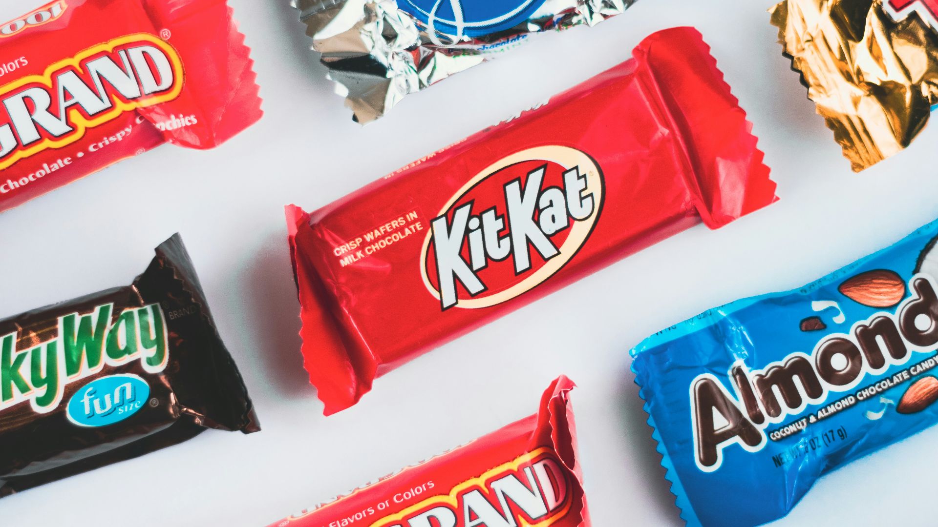 a variety of candy bars lined up on a white surface