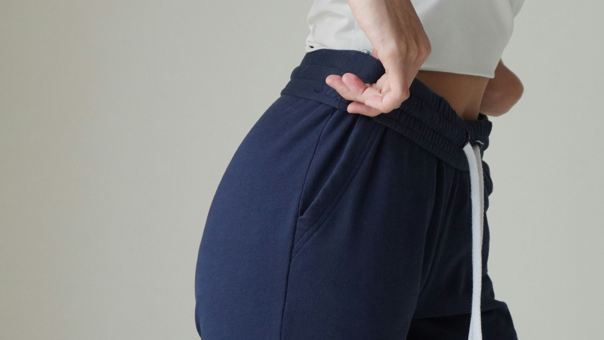 a woman in a white top and blue pants