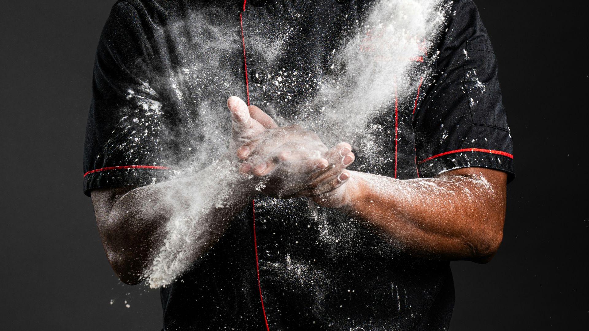 a man in a chef's uniform is sprinkled with flour