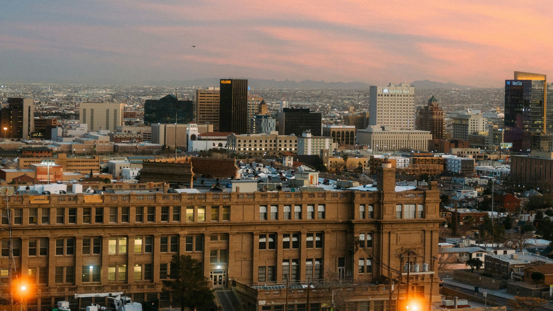 a view of a city at sunset from a hill