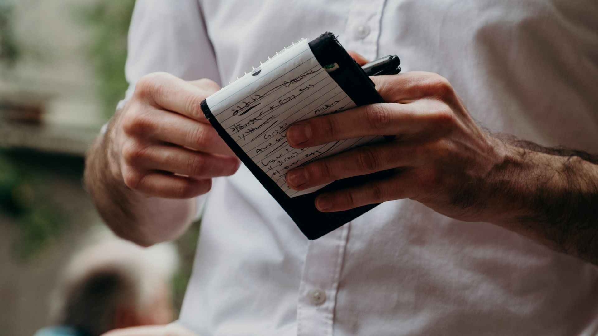 man in white button up shirt holding black and white box