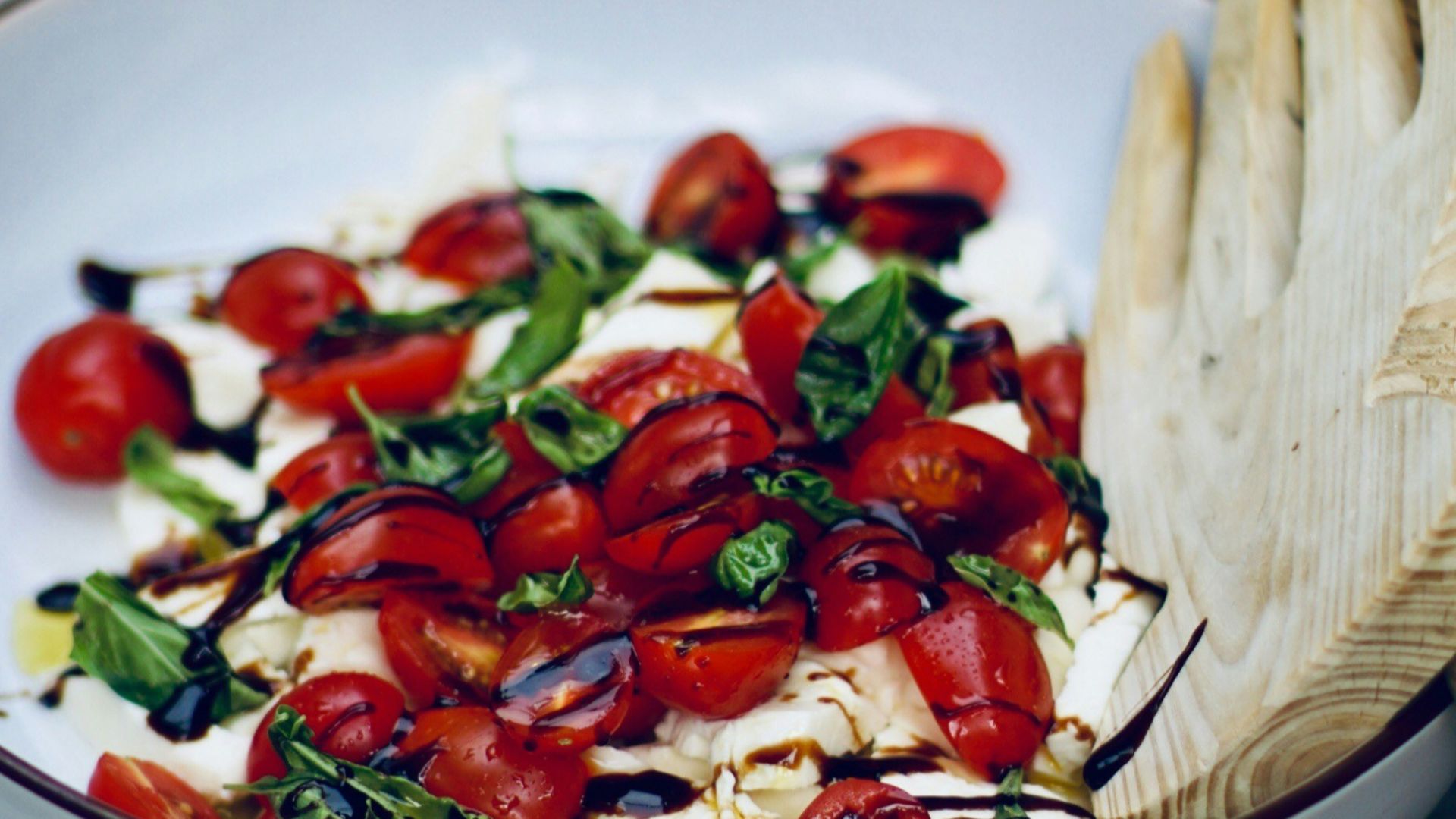 a white bowl filled with lots of food on top of a wooden table
